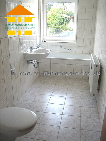 gefliestes Bad mit Wanne und Fenster
